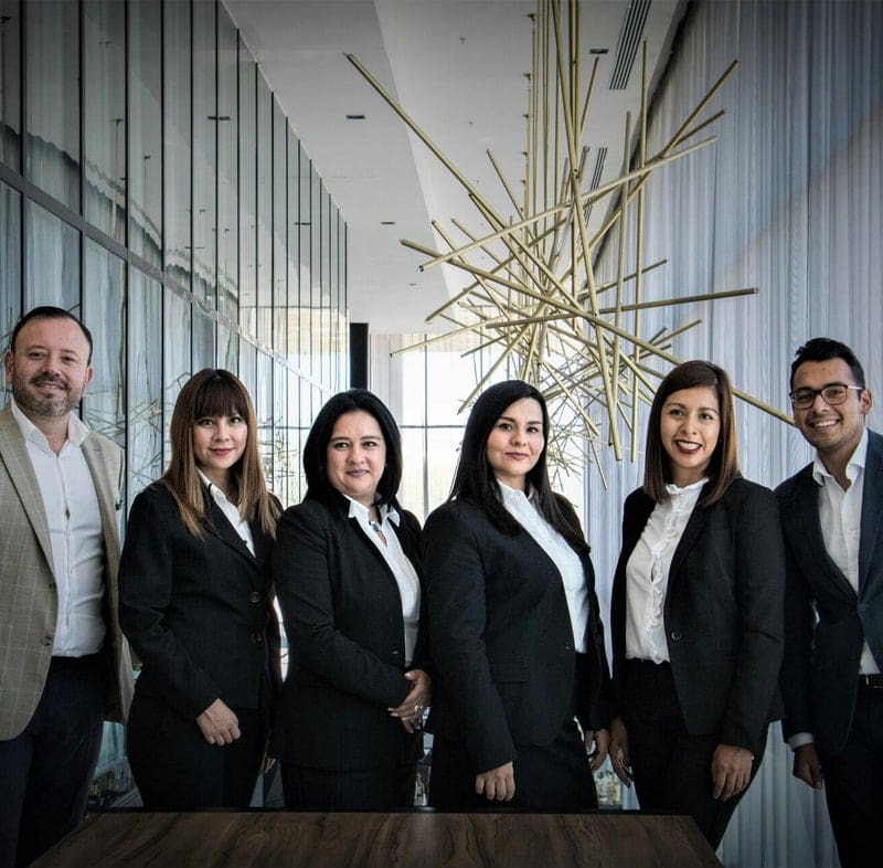 Equipo de seis personas de una empresa posando juntas en una oficina