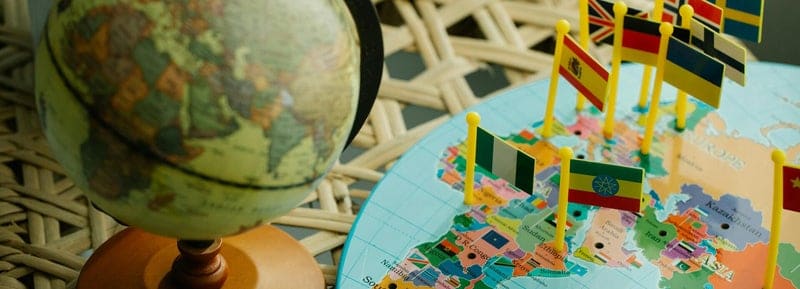 Globo terráqueo y mapa del mundo con banderas de varios países